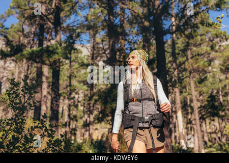 Randonneur femme trekking dans une forêt. Explorer la nature femme marchant à travers les bois. Banque D'Images