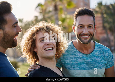 Portrait of handsome man standing outside avec friends smiling Banque D'Images
