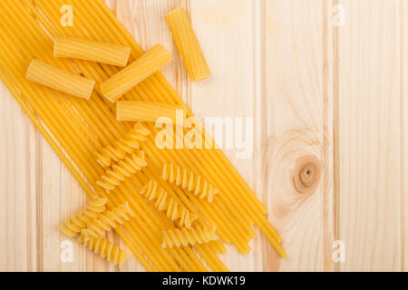 Sélection des matières style italien spaghetti pâtes non cuites et les fusilli rigatoni avec copie de l'espace sur un fond de bois en pin Banque D'Images