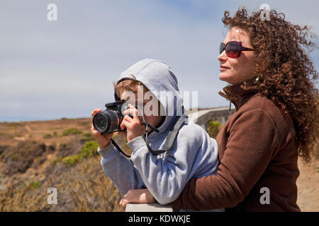 Jeune garçon à prendre des photos avec un appareil photo, San Simeon, San Luis Obispo County, Californie, USA (Mr) Banque D'Images