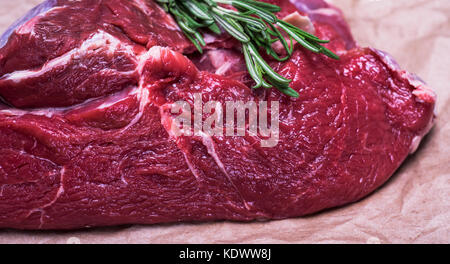 Morceau de viande fraîche de boeuf avec un brin de romarin, Close up Banque D'Images