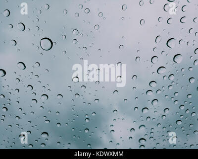 Gouttes d'eau sur un verre, sur un fond bleu Banque D'Images