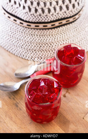 La gelée rouge, coupé en dés, à l'intérieur de deux verres de verre, sur la table Banque D'Images