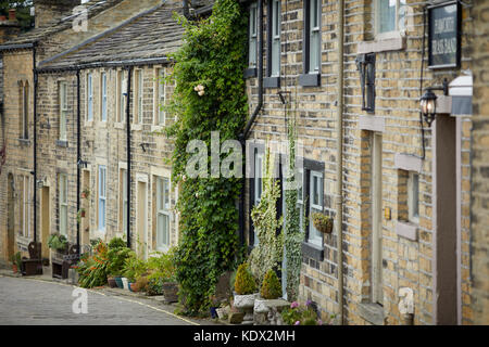 Pennines village, Haworth dans le West Yorkshire, Angleterre. touristes se mêlent sur la rue main, une route pavée bordée de boutiques intéressantes et co en terrasses Banque D'Images