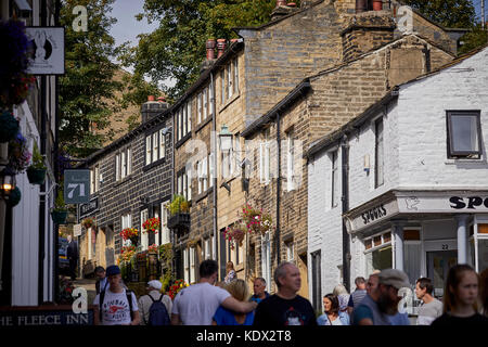 Pennines village, Haworth dans le West Yorkshire, Angleterre. chalets et les entreprises sur l'abrupte Rue principale Banque D'Images