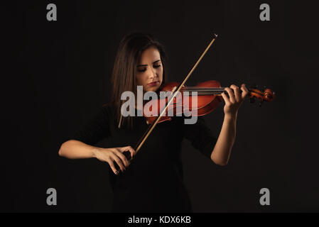 Belle femme violoniste au violon sur fond noir Banque D'Images