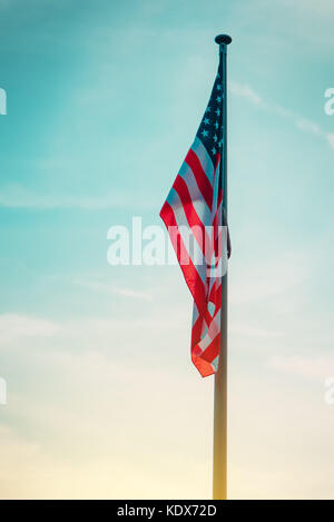 Usa drapeau sur poteau dans le coucher du soleil, american national bannière avec stars and stripes dans la soirée Banque D'Images