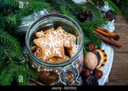 Gingerbread cookies de noël étoiles dans le bocal en verre avec des branches de sapin de noël, épices et décoration close up Banque D'Images