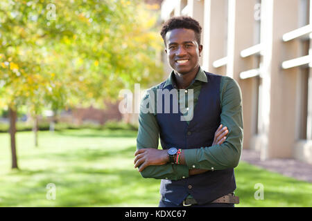 Voir la mise au point sélective d'un certain beau jeune étudiant noir homme sourit sur college Campus Banque D'Images