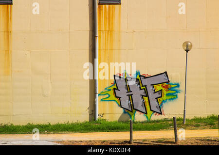 Graffitis illégaux mais artistiques sur un mur de plâtre de couleur crème à Aluberia au Portugal Banque D'Images