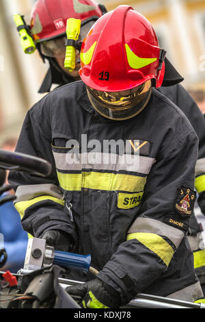 Zamosc/Pologne - août 13,2017 : les pompiers qui travaillent sur un véhicule automobile avec un dégagement d'énergie hydraulique de l'outil de sauvetage. lettres straz signifie pompier Banque D'Images