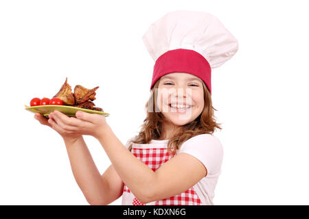 Happy little girl cook avec ailes de poulet grillé Banque D'Images