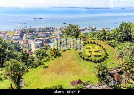 Paysage ville sandakan avec pelouse verte en forme de svastika hindou des aiguilles et le bleu de la mer de Sulu à l'arrière-plan, Bornéo, Malaisie Banque D'Images