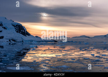 Polaire orange coucher de soleil sur les montagnes de glaciers et la dérive des icebergs fondu à l'antarctique, du détroit de lemaire Banque D'Images