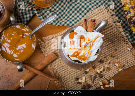 Vue de dessus de tasse de crème fouettée et arrosé de caramel sur le dessus de cannelle Banque D'Images