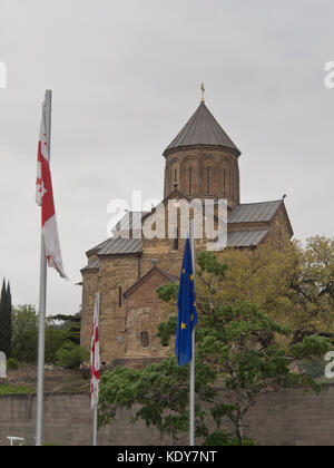 Vierge Marie dans l'église de Metekhi Tbilissi Géorgie sur une colline au-dessus de la place de l'Europe, avec des drapeaux de l'UE et la Géorgie Banque D'Images