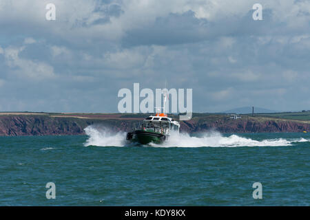 Le bateau pilote st govan en prenant un pilote sur un navire à travers la houle à l'entrée de Milford Haven sur une voie navigable summers matin. Banque D'Images