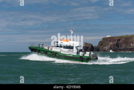 Le bateau pilote st govan en prenant un pilote sur un navire à travers la houle à l'entrée de Milford Haven sur une voie navigable summers matin. Banque D'Images