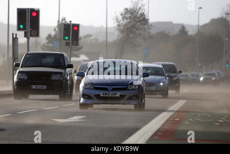 Sur la photo : Voitures voyageant sur la route d'Oystermouth blasted obtenir soufflé par le sable de la plage de Swansea, Royaume-Uni. Lundi 16 octobre 2017 Re : Vestiges de l'ouragan Banque D'Images