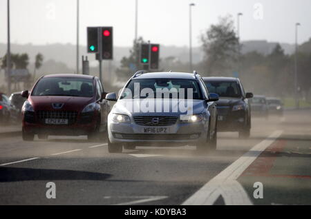 Sur la photo : Voitures voyageant sur la route d'Oystermouth blasted obtenir soufflé par le sable de la plage de Swansea, Royaume-Uni. Lundi 16 octobre 2017 Re : Vestiges de l'ouragan Banque D'Images