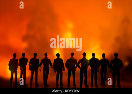 Silhouettes de personnes regardant le feu dans la forêt, conceptual image Banque D'Images