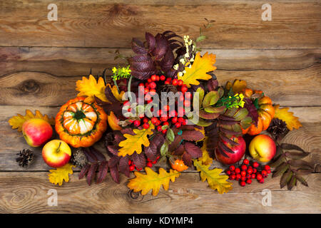 Centre de table de Thanksgiving avec rowan berries, Cônes, pommes, citrouilles, Rowan et feuilles de chêne sur le fond en bois rustique, vue du dessus Banque D'Images