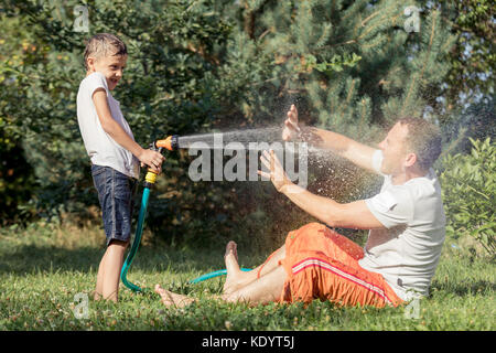 Heureux père et fils jouer dans le jardin à la journée. Les gens s'amusant oudoors. concept de famille heureuse. Banque D'Images