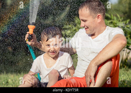 Heureux père et fils jouer dans le jardin à la journée. Les gens s'amusant oudoors. concept de famille heureuse. Banque D'Images