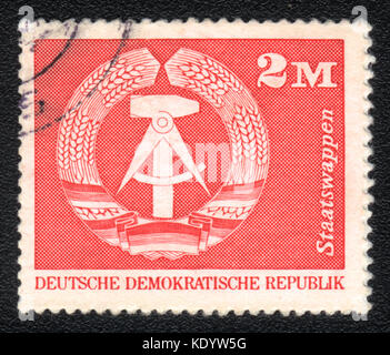 Un timbre-poste imprimé en montre l'emblème de la DDR DDR, circa 1975 Banque D'Images