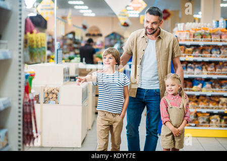 Père avec des enfants dans un supermarché Banque D'Images