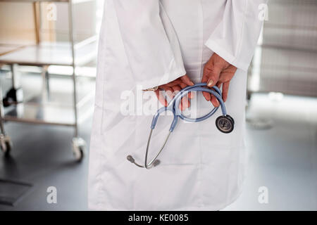 Female doctor holding stethescope. Tourné à l'arrière, pas de tête en photo. Bon, salle de l'Hôpital clinique de style de l'entreprise Banque D'Images