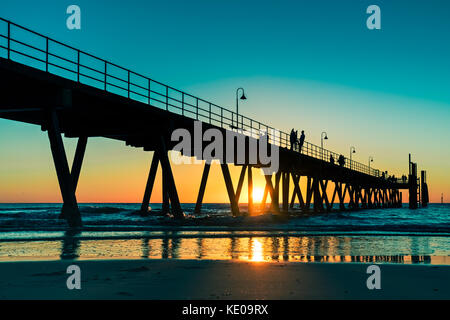 La plage de Glenelg coucher de soleil avec des gens sur la jetée à Adelaide, Australie du Sud Banque D'Images