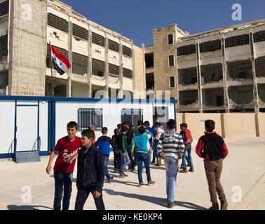 (171017) -- ALEP, 17 octobre 2017 (Xinhua) -- les élèves jouent à des jeux dans de simples salles de classe préfabriquées à l'école Ibrahim al-Tanbi, Alep, Syrie, le 12 octobre 2017. Le bâtiment de l'école a été déchiré en morceaux, mais les élèves de divers âges étudiaient dans de simples salles de classe préfabriquées aménagées par le gouvernement dans la cour. Autrefois utilisées par les rebelles comme bases, les écoles de la ville d’Alep ont maintenant retrouvé leur fonction initiale de lieu d’éducation pour les enfants. (Xinhua/Zheng Yihan) (psw) Banque D'Images