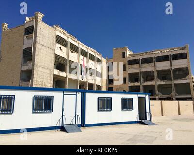 (171017) -- ALEP, 17 oct. 2017 (Xinhua) -- photo prise le 12 oct. 2017 montre des salles de classe préfabriquées simples à l'école Ibrahim al-Tanbi, Alep, Syrie. Le bâtiment de l'école a été déchiré en morceaux, mais les élèves de divers âges étudiaient dans de simples salles de classe préfabriquées aménagées par le gouvernement dans la cour. Autrefois utilisées par les rebelles comme bases, les écoles de la ville d’Alep ont maintenant retrouvé leur fonction initiale de lieu d’éducation pour les enfants. (Xinhua/Zheng Yihan) (psw) Banque D'Images