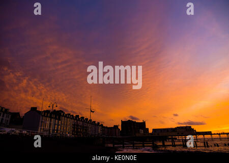 Pays de Galles Aberystwyth uk, le mardi 17 octobre 2017 uk weather : une belle et dramatique ciel rouge au coucher du soleil au-dessus de la station balnéaire d'Aberystwyth royal pier sur la côte ouest de la baie de Cardigan au Pays de Galles Crédit photo : Keith morris/Alamy live news Banque D'Images