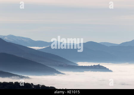 Dans la vallée de l'Ombrie (Italie) rempli par le brouillard, avec la brume au-dessus de la ville de Trevi Banque D'Images