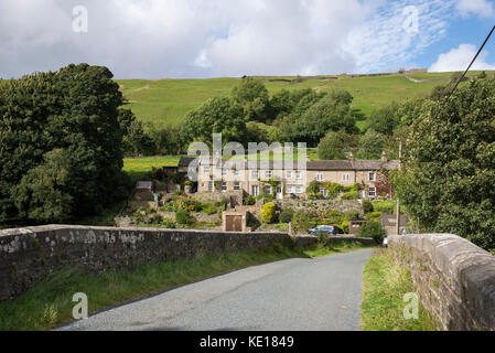 Rangée de cottages à côté de la rivière swale à basse ligne dans les vallées du Yorkshire, Angleterre. Banque D'Images