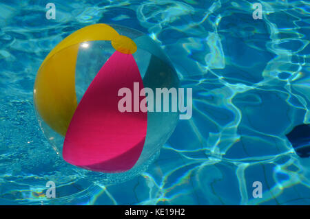 Beach ball floating in swimming pool Banque D'Images