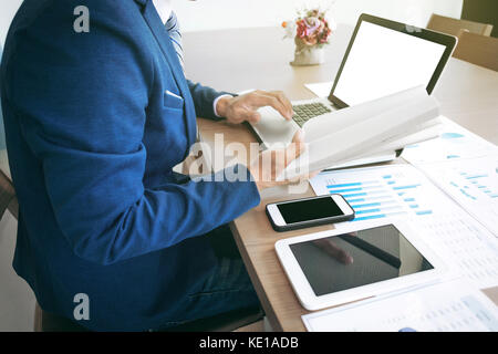 Jeune homme travaillant avec un ordinateur portable, tablette et smart phone, man's hands sur votre ordinateur portable, de personne d'affaires au lieu de travail. Banque D'Images