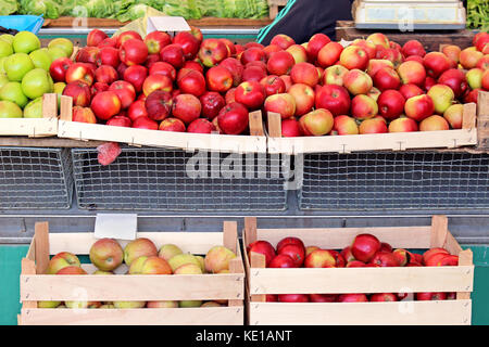 Les pommes biologiques dans des caisses en bois sur market stall Banque D'Images