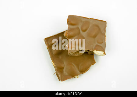 Nature morte avec une vue d'une table brisée de chocolat au lait avec amandes isolé sur fond blanc Banque D'Images