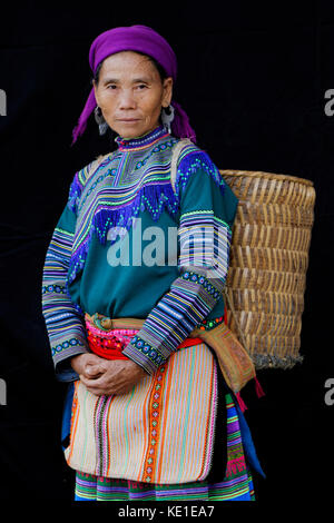 SIN CHENG, au Vietnam, le 26 octobre 2016 : Femme avec un sac en face d'une feuille noire. Les femmes HMong du Nord Vietnam porter leurs meilleurs vêtements traditionnels wh Banque D'Images