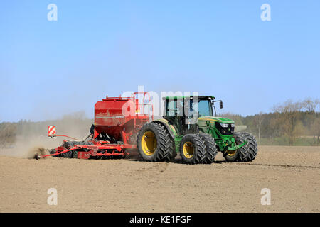 Salo, Finlande - le 8 mai 2016 : john deere 6125r tracteur agricole et semoir Horsch sur terrain poussiéreux au printemps avec ciel bleu. Banque D'Images