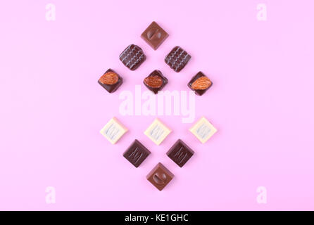 Collection de délicieux pralinés chocolat sur fond rose à la mode style laïcs. Télévision. place pour votre texte. Banque D'Images