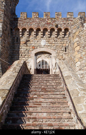 Brique et Pierre escalier menant à une entrée fermée d'un château dans le ciel bleu avec soleil du matin. Banque D'Images