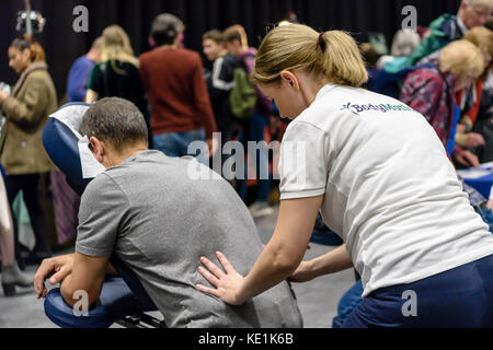 Une femme donne un massage à un festival vegan. Banque D'Images