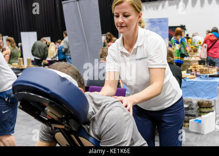 Une femme donne un massage à un festival vegan. Banque D'Images