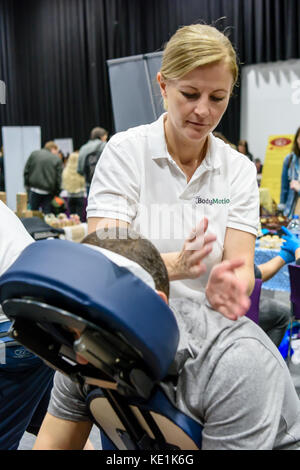 Une femme donne un massage à un festival vegan. Banque D'Images