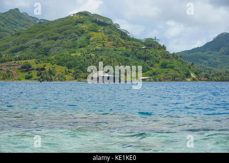 L'île du Pacifique sud en polynésie française huahine littoral avec une ferme perlière au-dessus de l'eau dans le lagon Banque D'Images