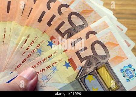 Une cinquantaine de billets en euro en main sous le pouce en arrière-plan Banque D'Images